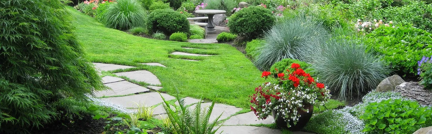 Backyard pond and waterfall with stone borders and deck seating, built by Earthworks Landscape Service